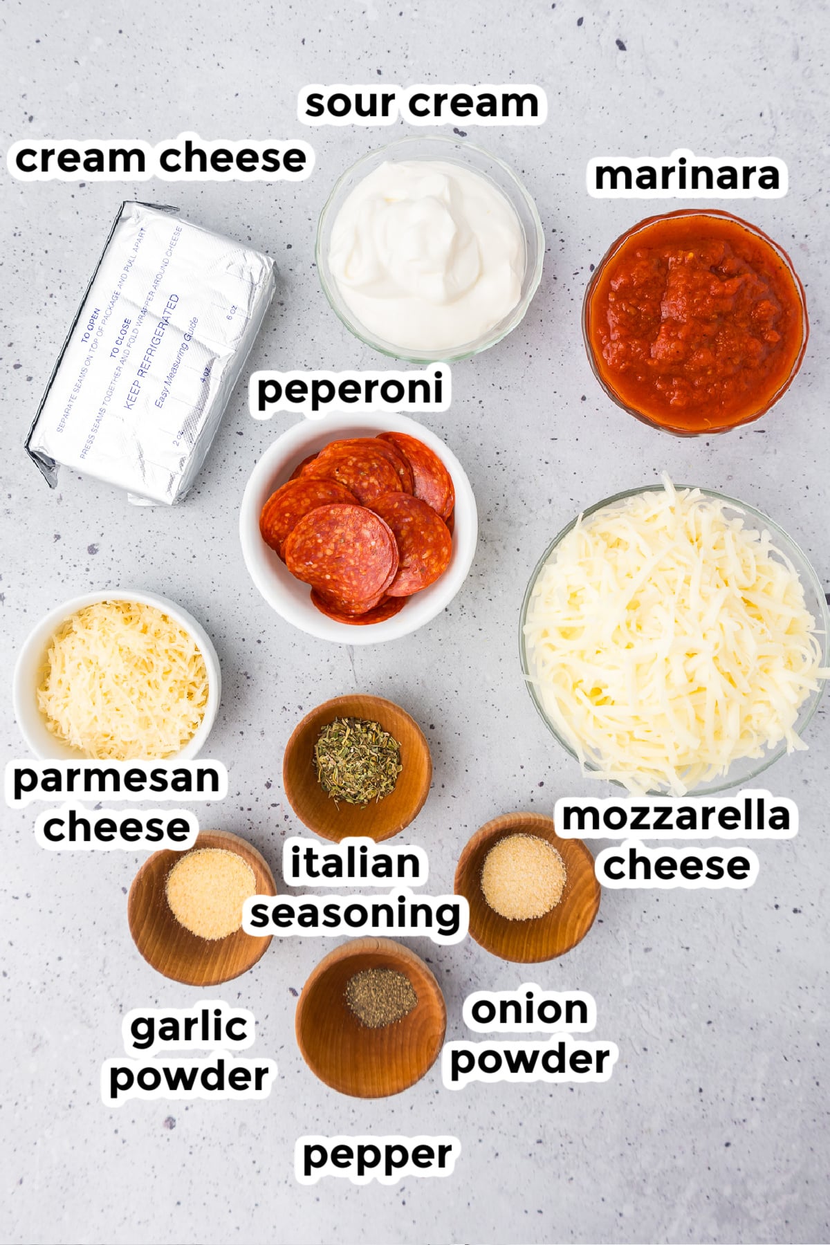 Ingredients for a pepperoni dip in bowls with text labels.