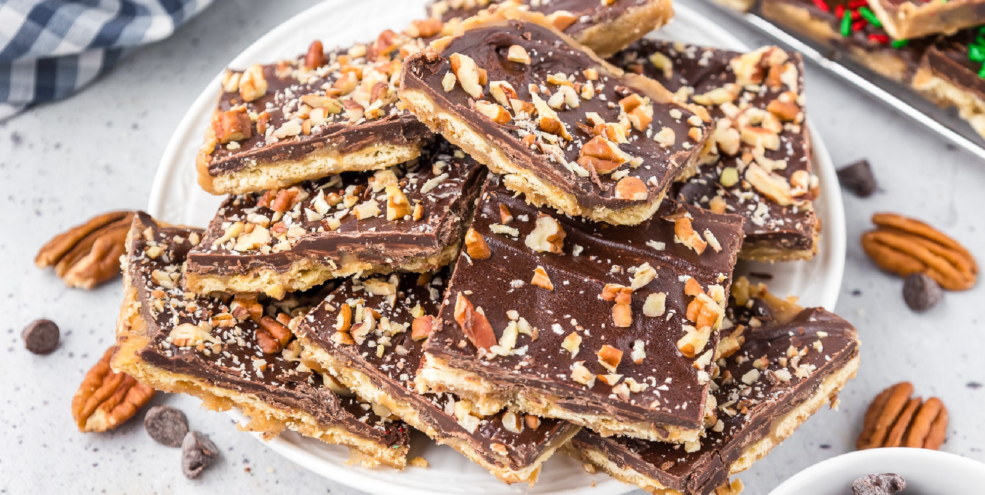 Wide view of chocolate saltine toffee stacked on a serving plate.