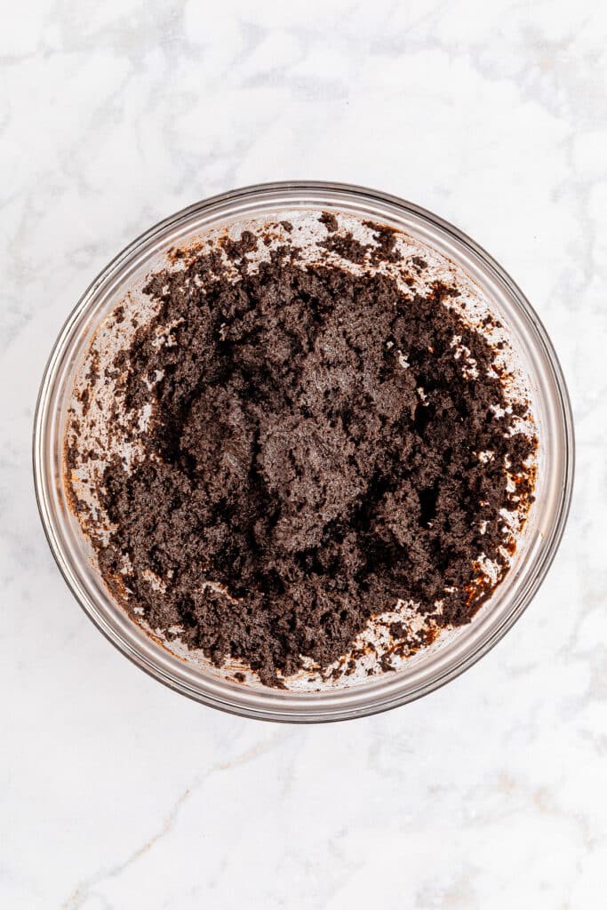 A bowl of chocolate Oreo cookie crumbs mixed with cream cheese from above.