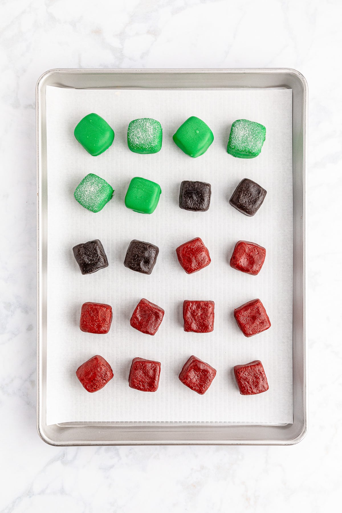 A tray of square present shaped truffles with half dipped in chocolate candy melts.