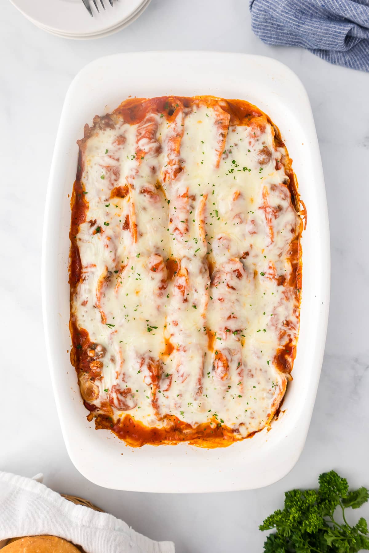 Cooked ground beef stuffed shells covered in melted cheese in a casserole dish from above.
