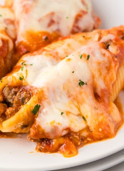Close up stuffed shells with ground beef and cheese on a plate.