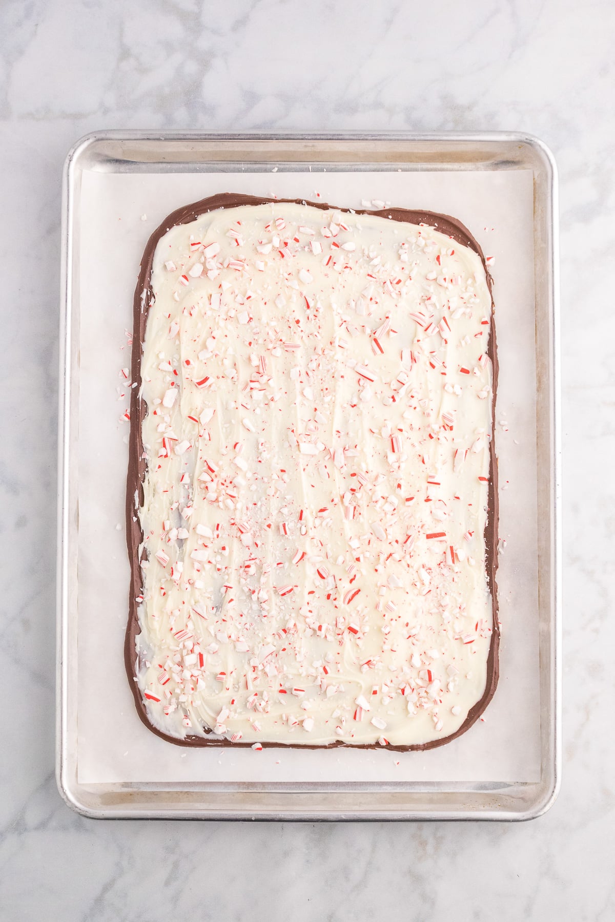 White chocolate peppermint bark in a large piece on a baking sheet.
