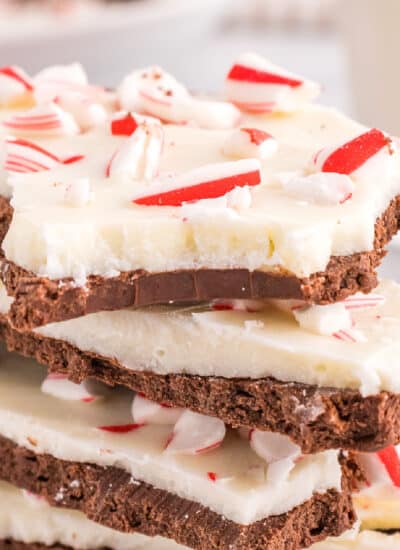 Peppermint bark stacked on top of each other close up with the top piece missing a bite.