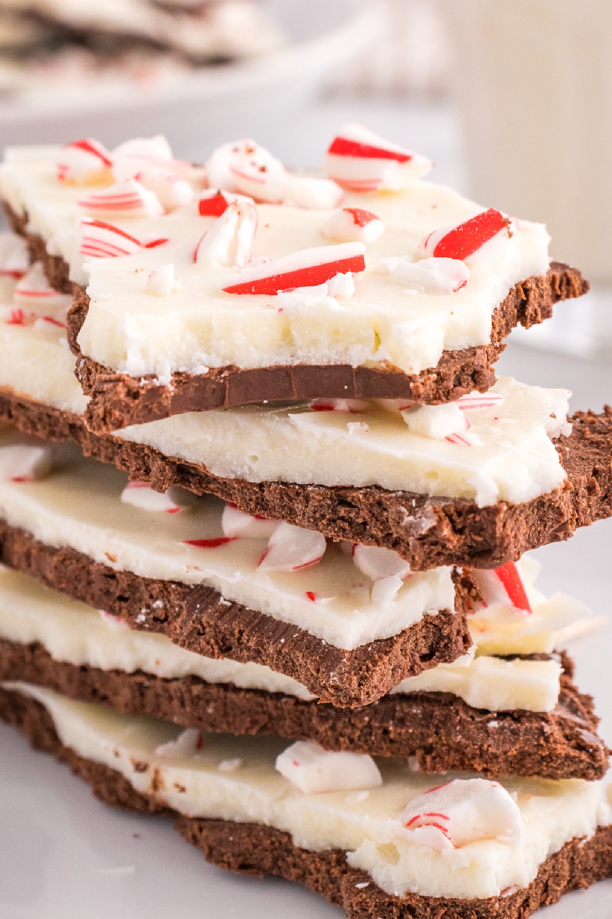 A stack of peppermint bark with the top piece missing a bite.
