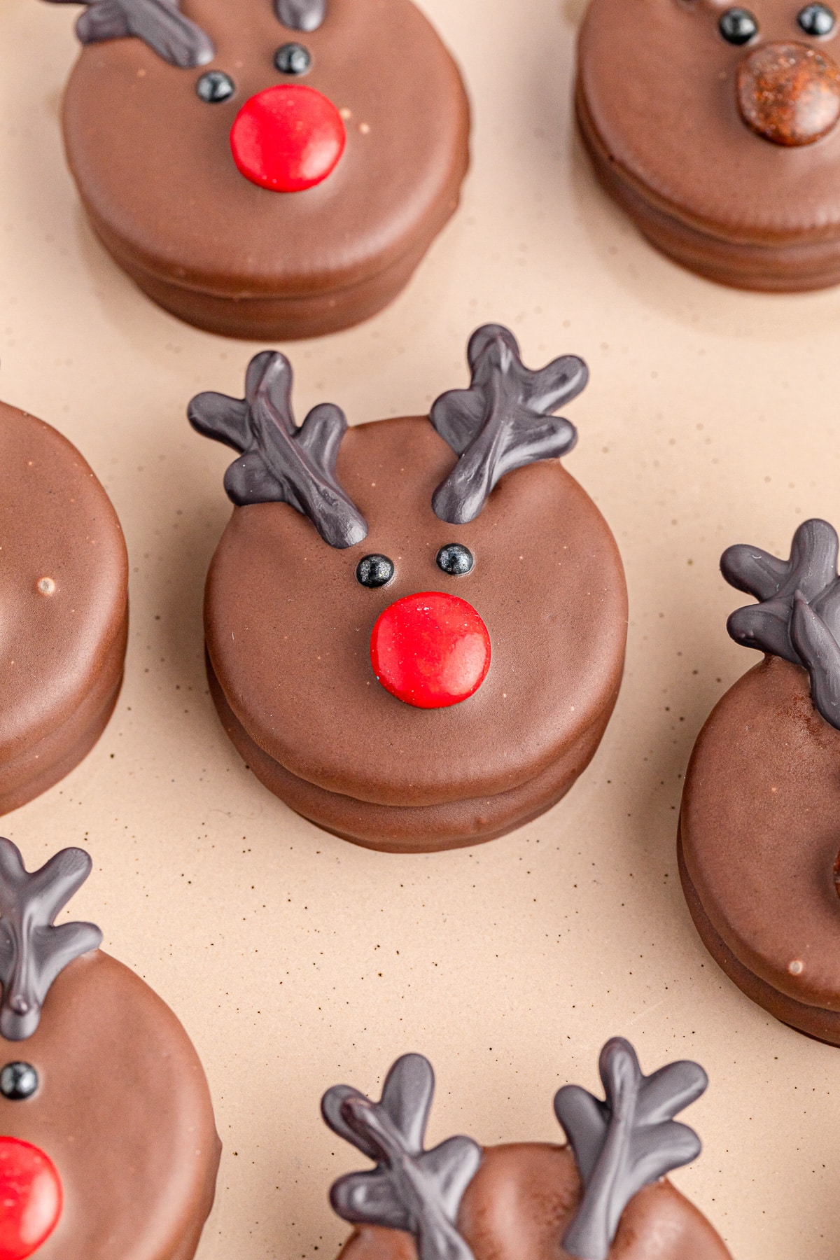 Chocolate reindeer Oreo cookies decorated with red candy noses.