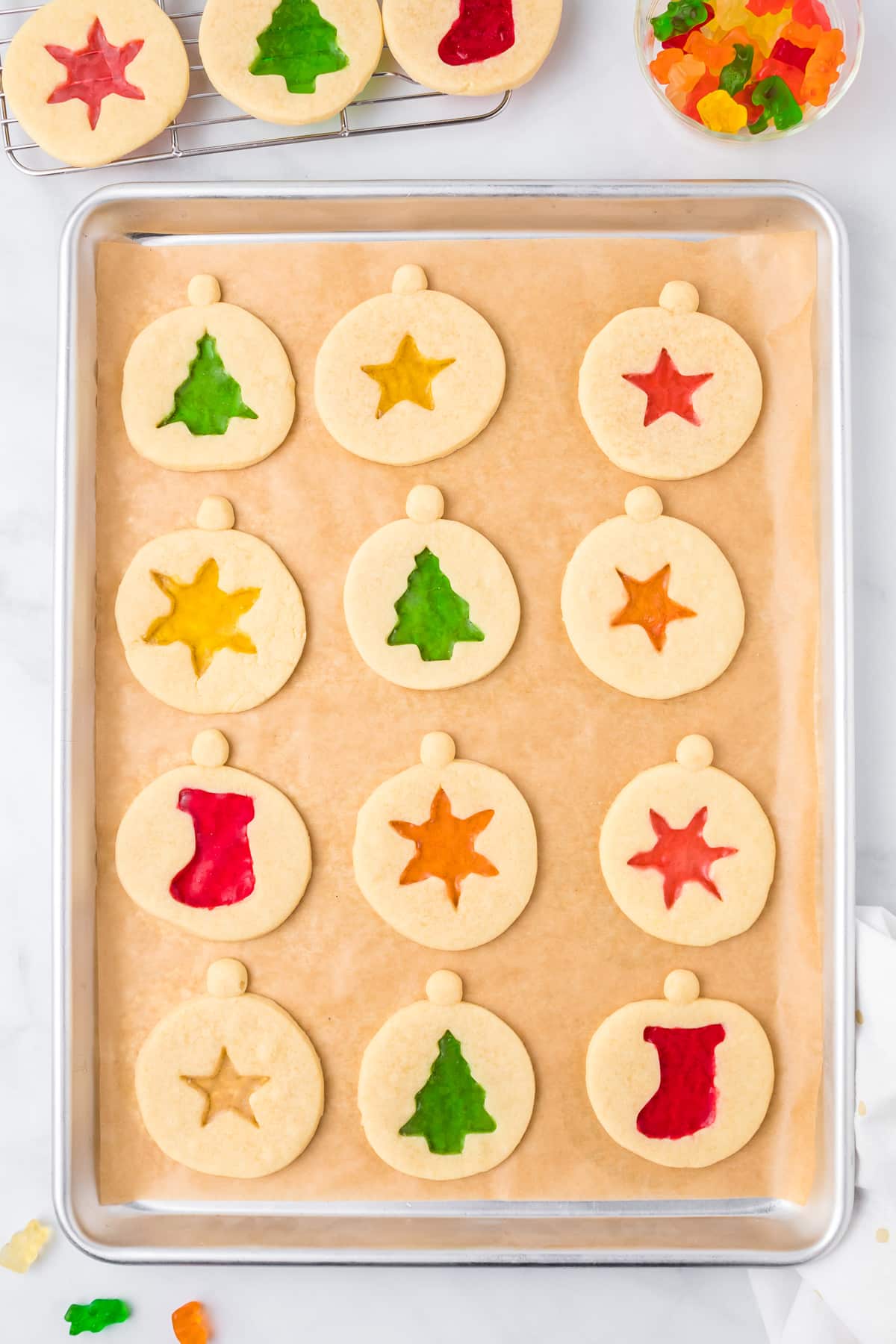 Christmas cookies with gummy bears on a baking sheet.