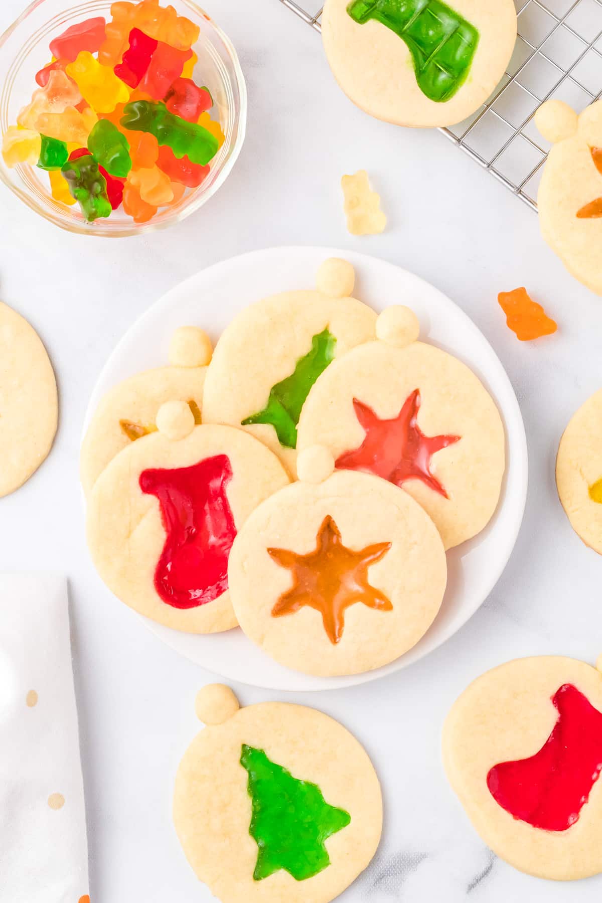 Christmas cookies with gummy candy on a plate.