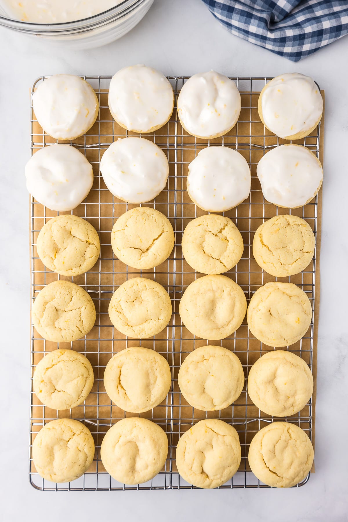 Lemon cookies on a cooling rack with a third of the cookies dipped in glaze.
