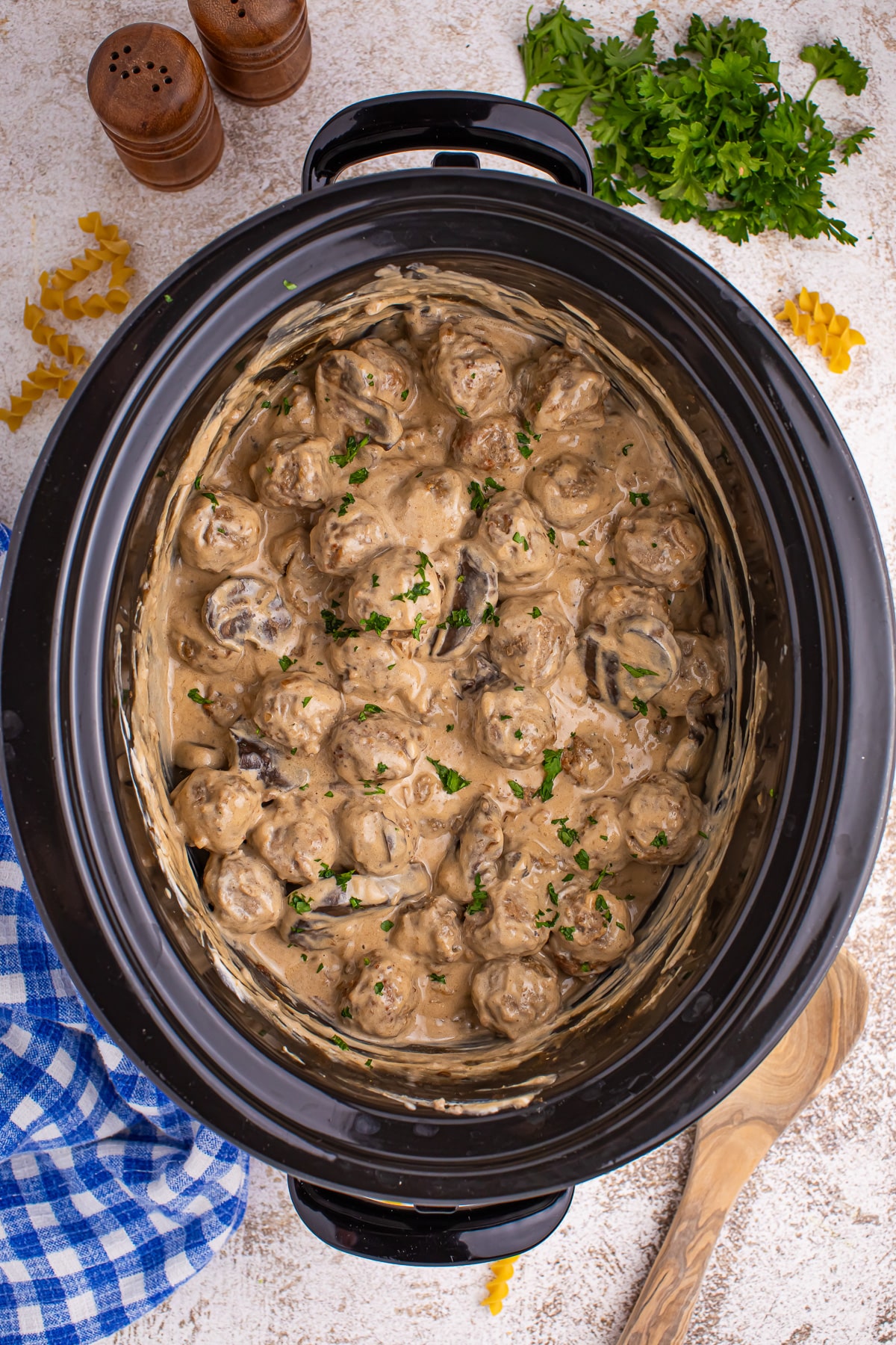 A crock pot filled with meatball stroganoff in a creamy sauce.