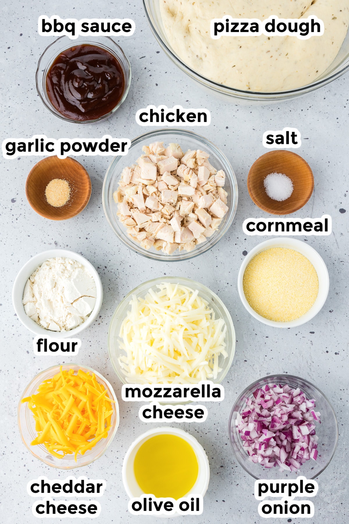 Ingredients for bbq chicken pizza in bowls on a counter with title text labels.