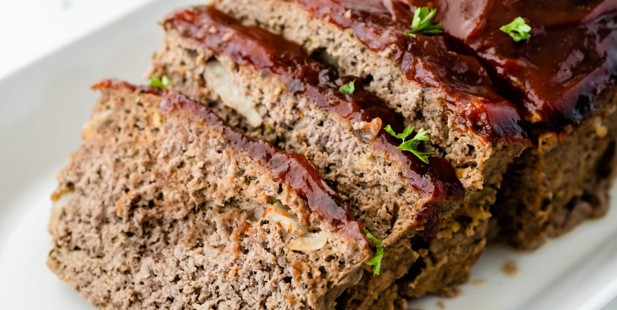 Sliced meatloaf up close on a platter.