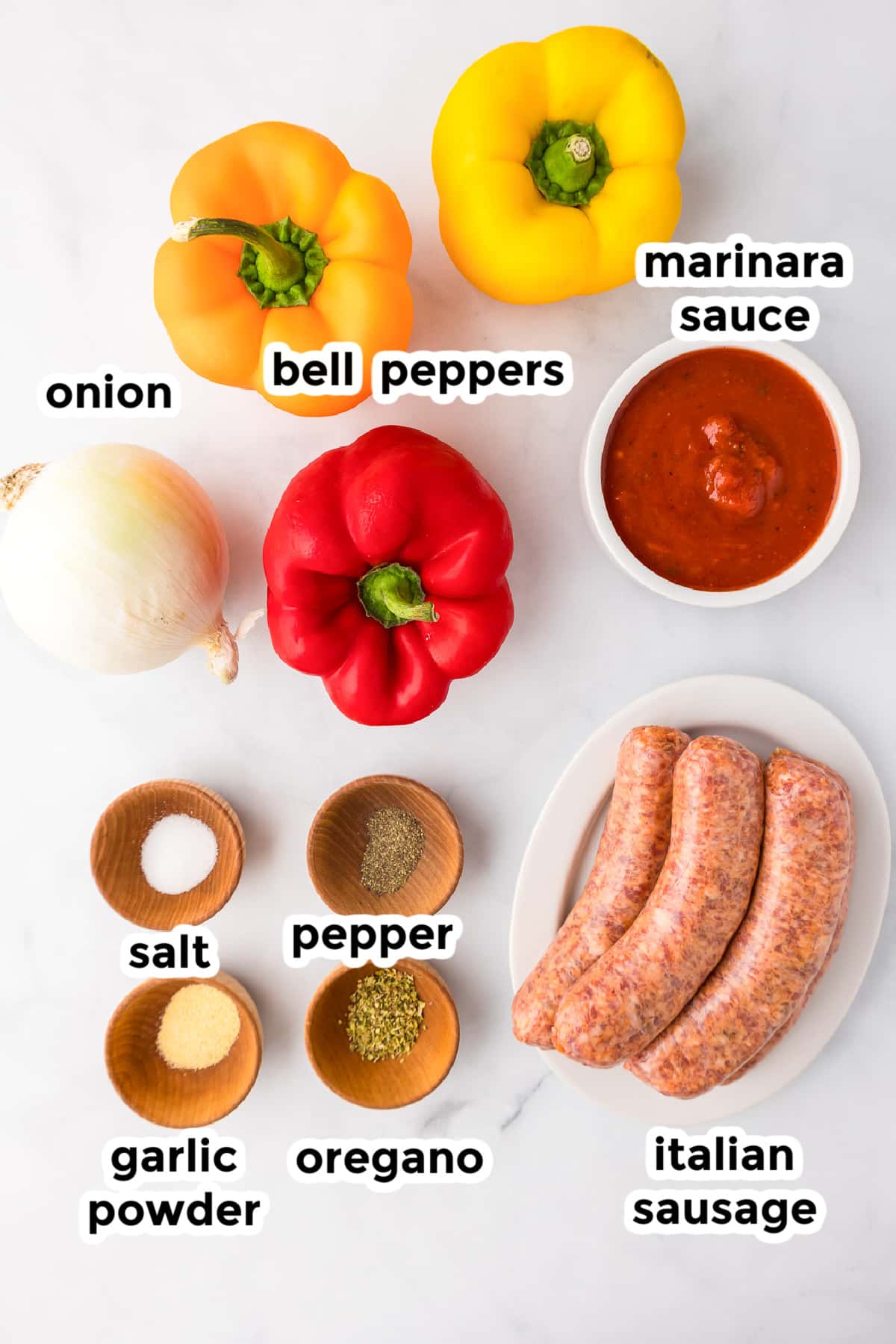 Ingredients for sausage peppers and onions in bowls on a kitchen counter with text labels.