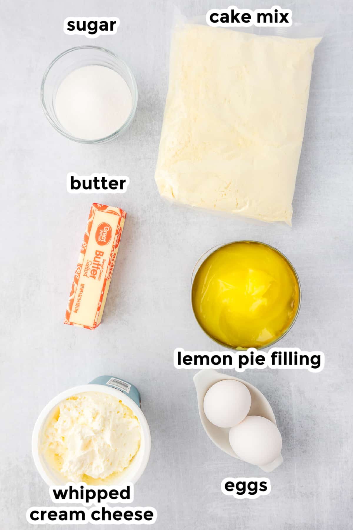 Ingredients for a lemon dump cake in bowls with title text labels.