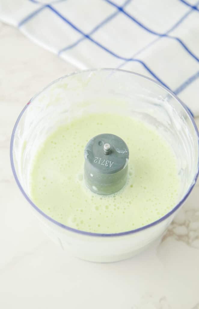 A blender containing freshly blended cucumber and yogurt mixture for dog treats.