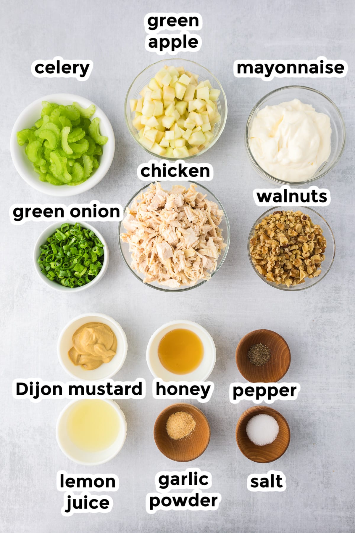 Ingredients for a apple walnut chicken salad in bowls with title text overlay.