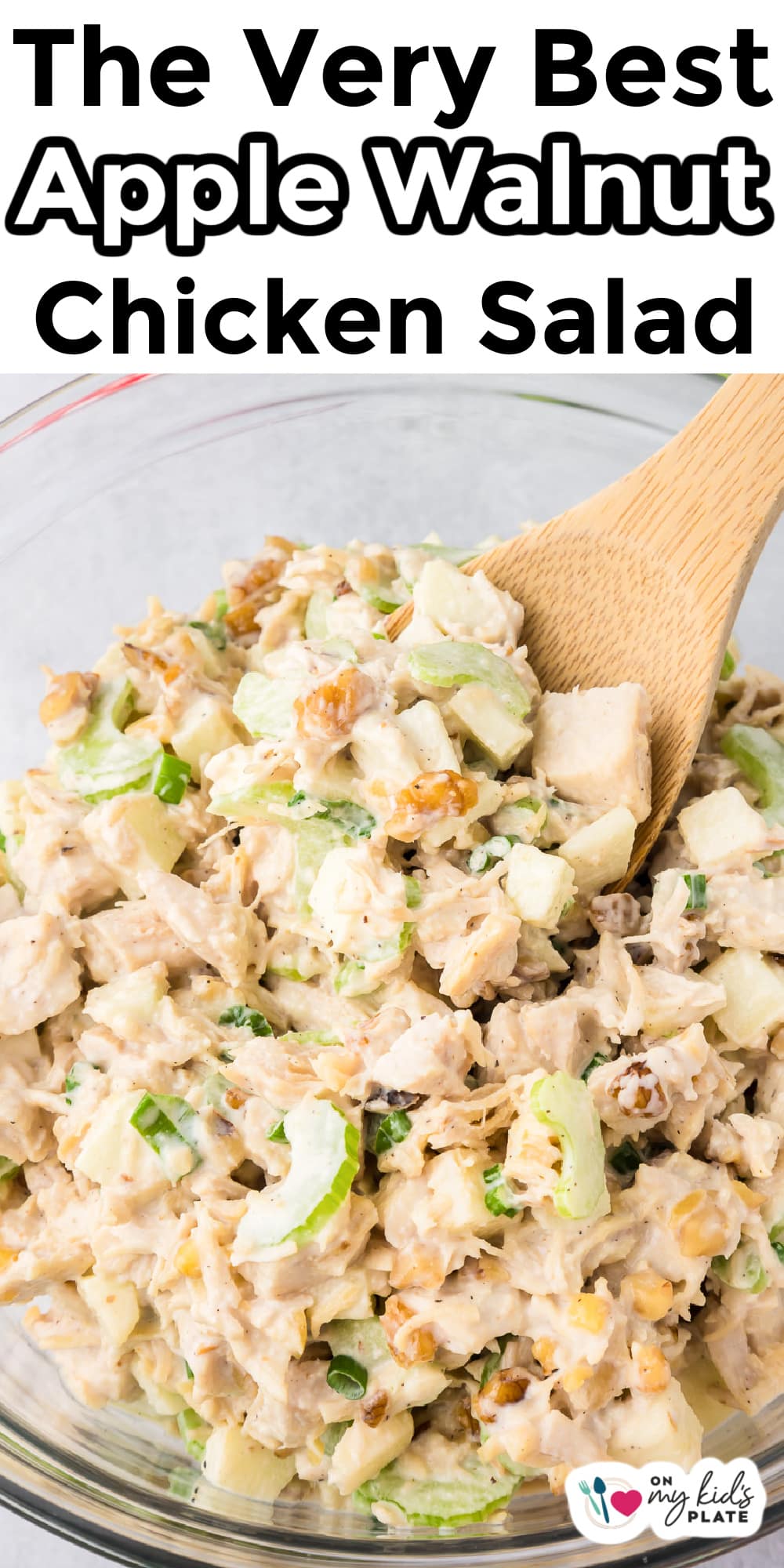Apple walnut chicken salad in a bowl being scooped with a spoon with title text overlay.