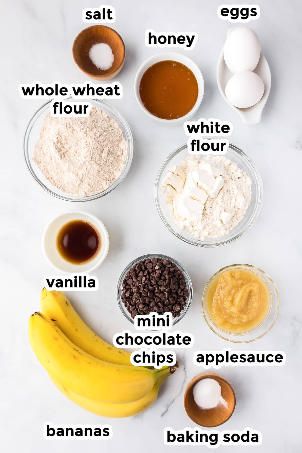 Ingredients for Banana Chocolate Chip Mini Muffins on a counter with text labels.