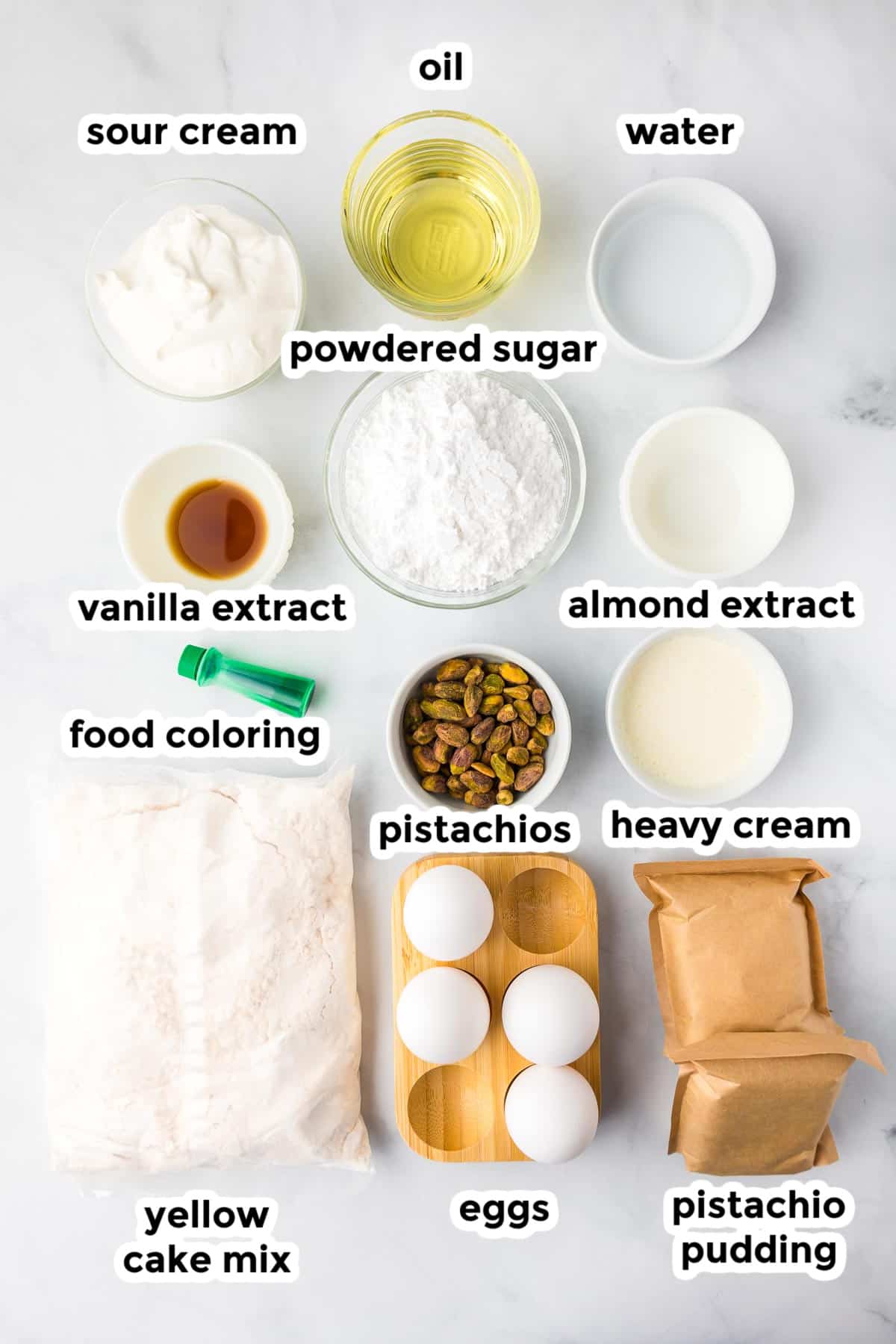 Ingredients for pistachio bread in bowls on a counter from overhead with text labels.