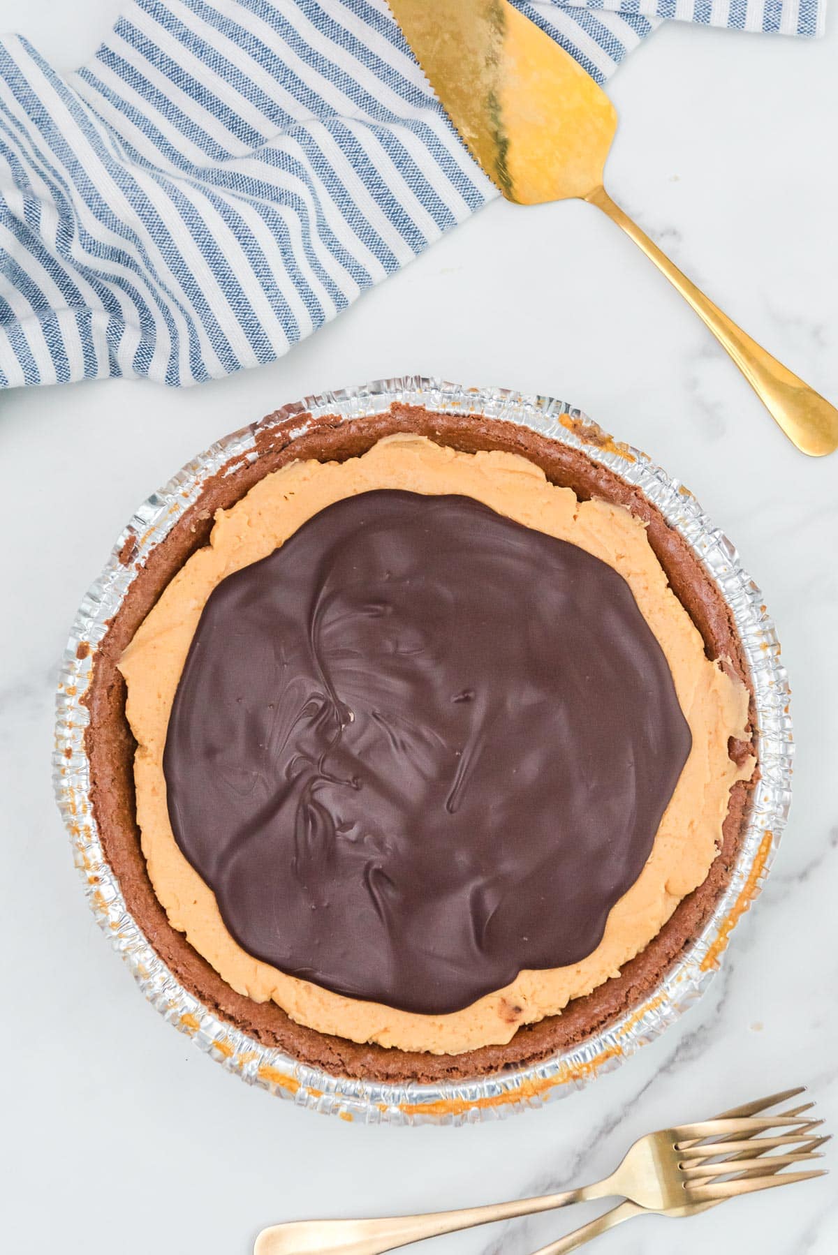 A chocolate-covered buckeye pie after chilling with a firm chocolate topping on a counter.