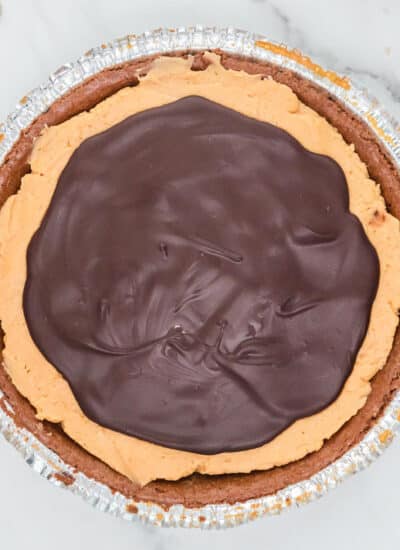 A buckeye pie in a foil container with a peanut butter filling and a layer of chocolate on top.