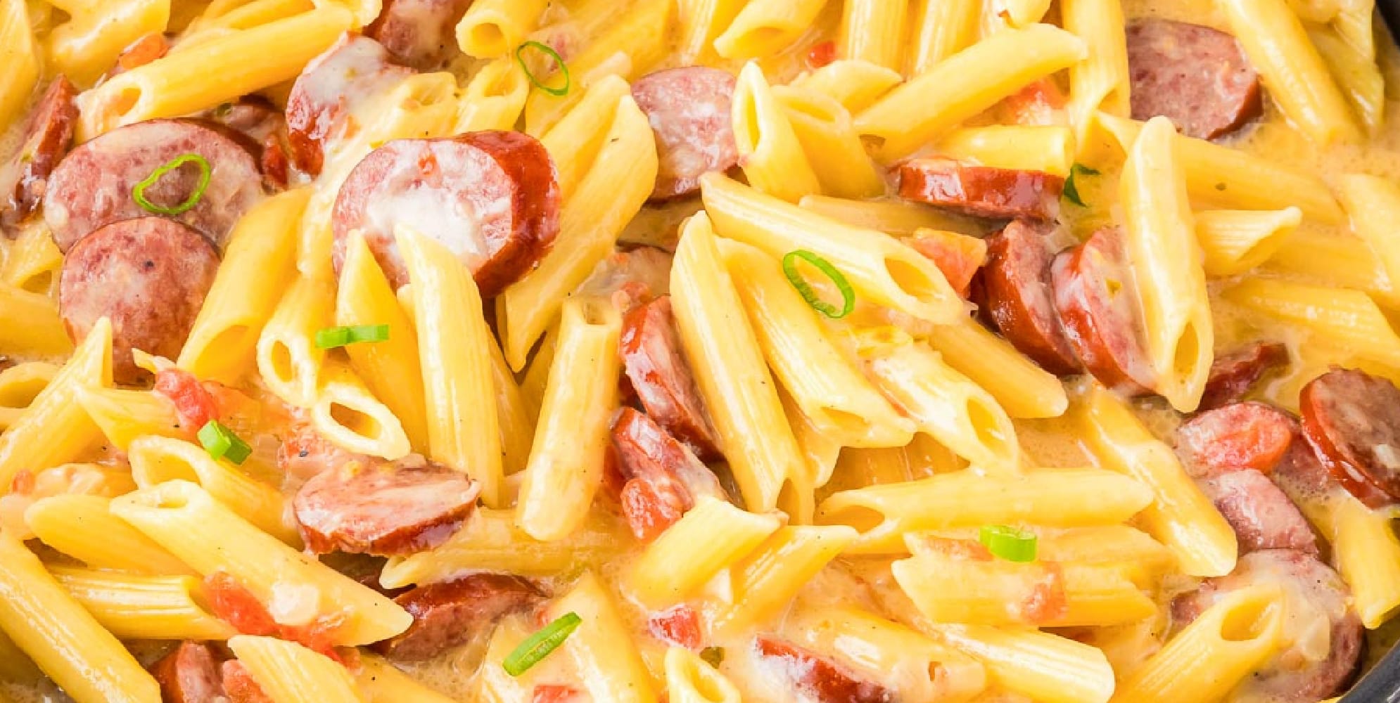 Close-up of a creamy cheesy smoked sausage pasta.