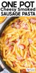 A skillet filled with penne pasta, slices of smoked sausage, and a cheesy sauce with text at the top reads "One Pot Cheesy Smoked Sausage Pasta.