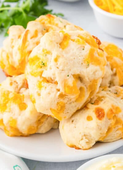 A plate of garlic cheddar cheese drop biscuits on a counter.