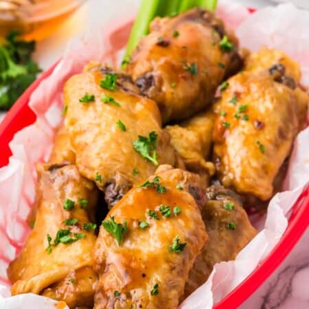 A red basket full of bbq chicken wings.