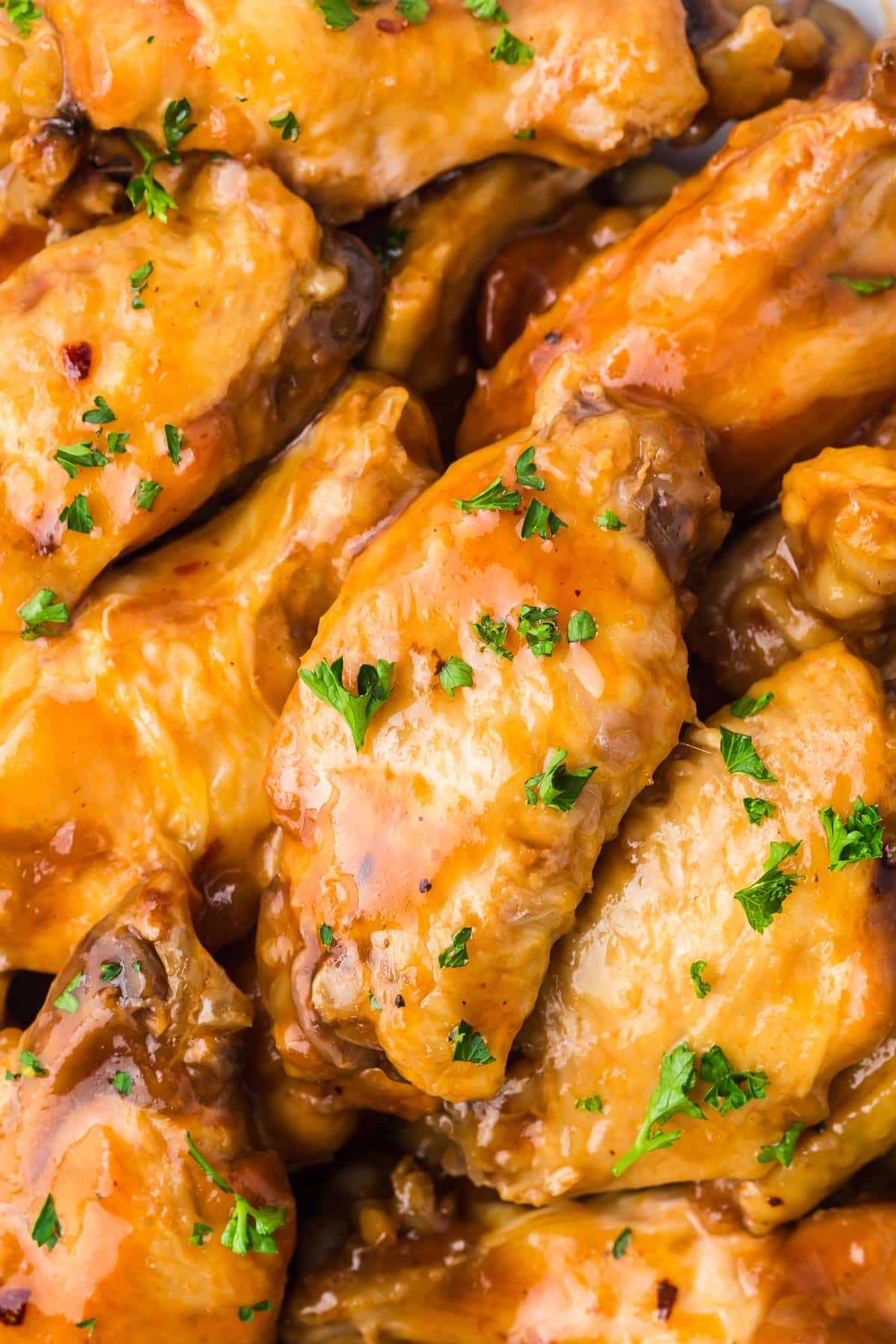 Close-up of golden-brown bbq chicken wings in a crock pot.