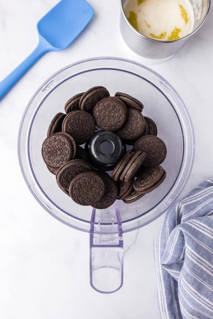 A food processor filled with chocolate oreo cookies from above.