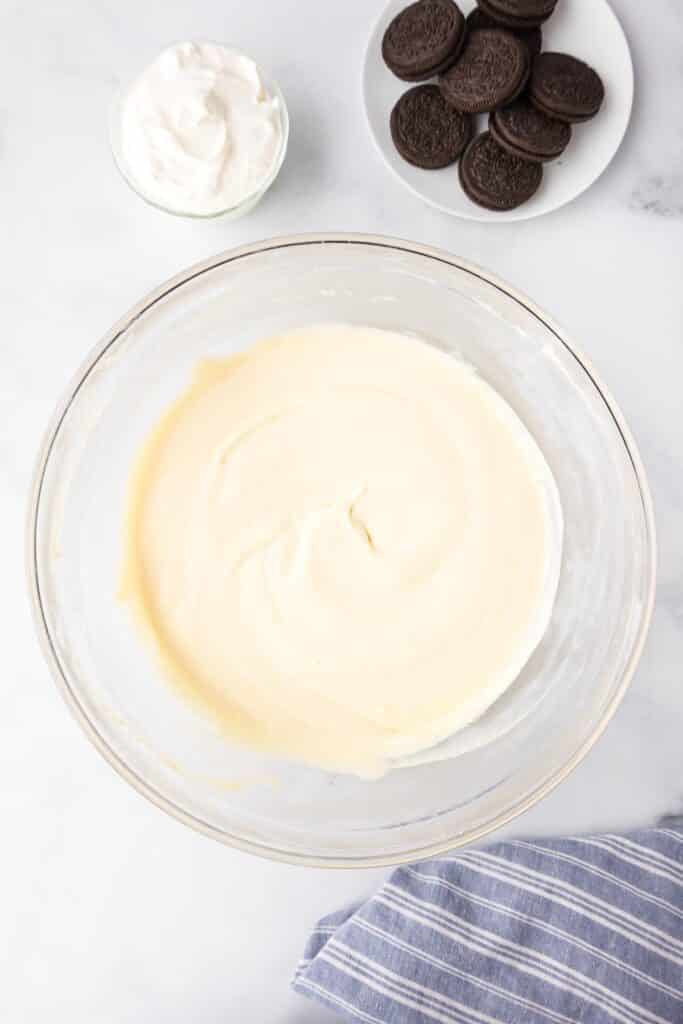 A large mixing bowl filled with a creamy cream cheese mixture.
