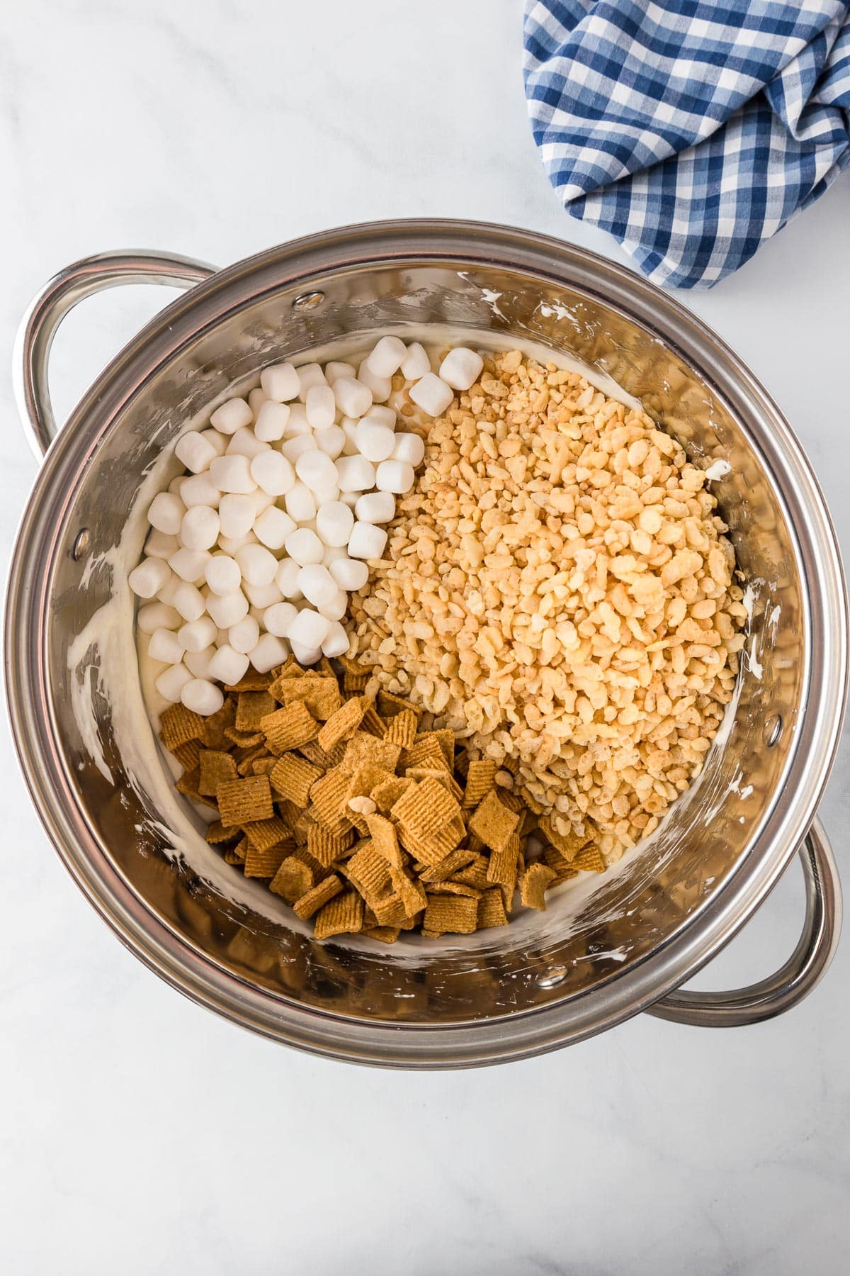 A large metal bowl with Golden Grahams cereal, Rice Krispie cereal and mini marshmallows.