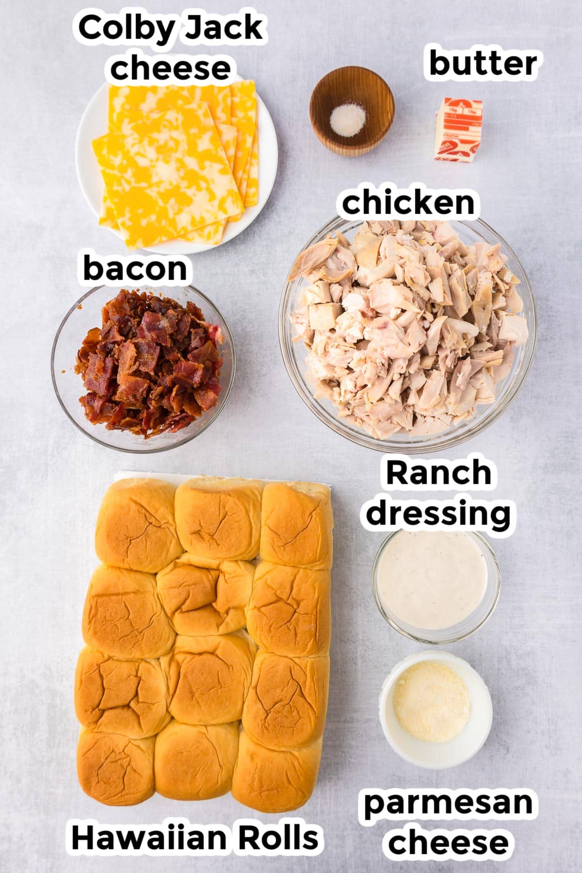 Ingredients for a chicken bacon ranch sliders on a counter in bowls with text labels.