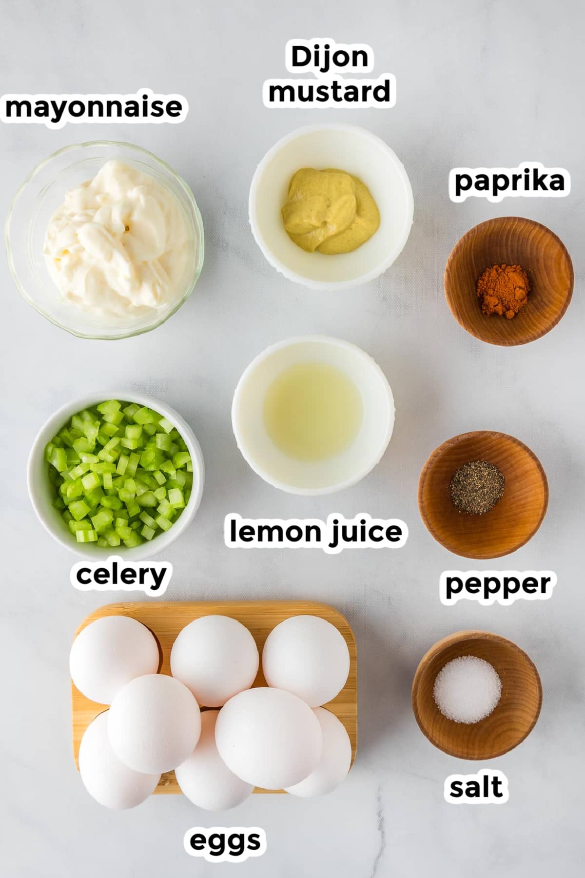 Ingredients for egg salad in bowls with title text labels.