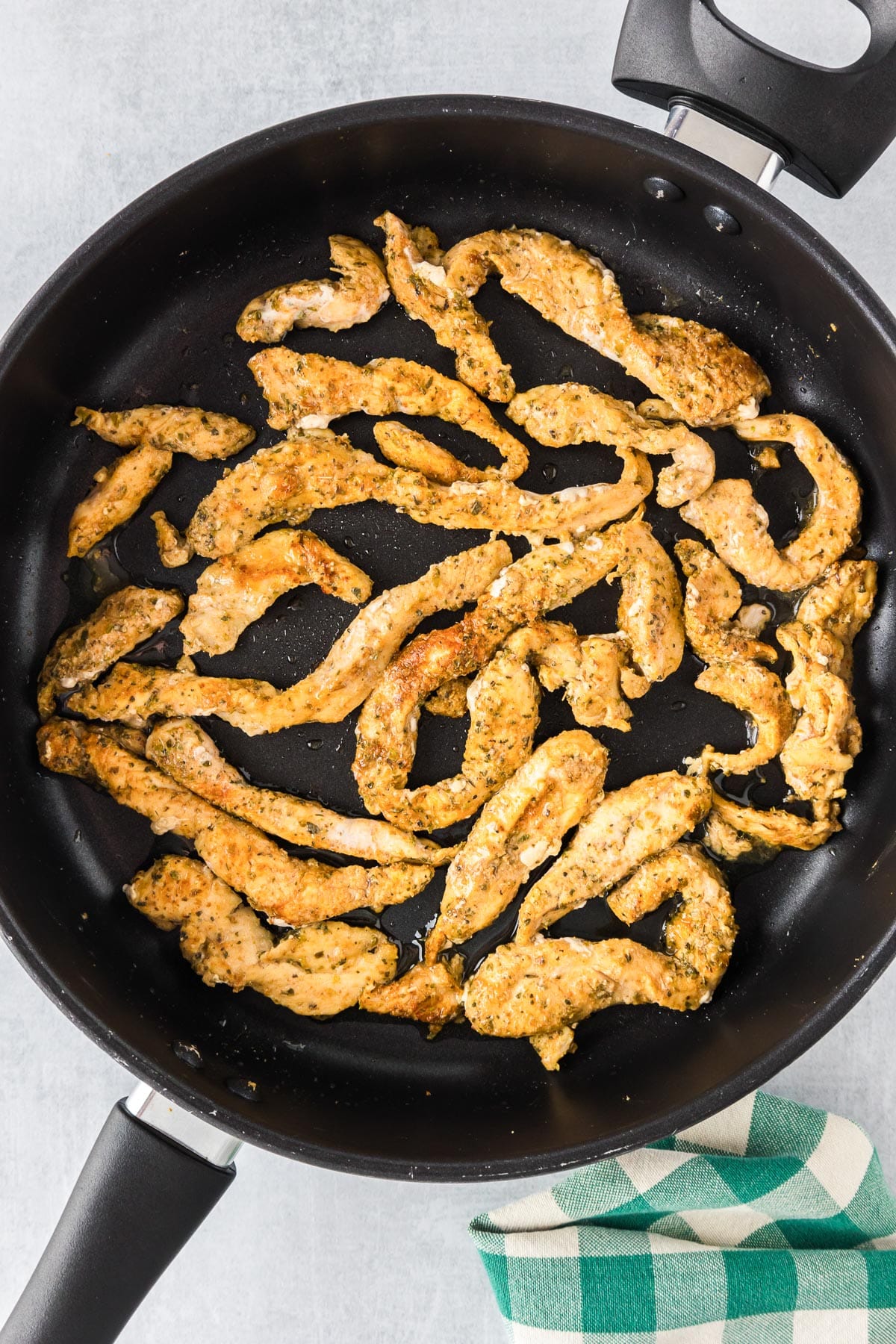 Cooked chicken pieces in a skillet.