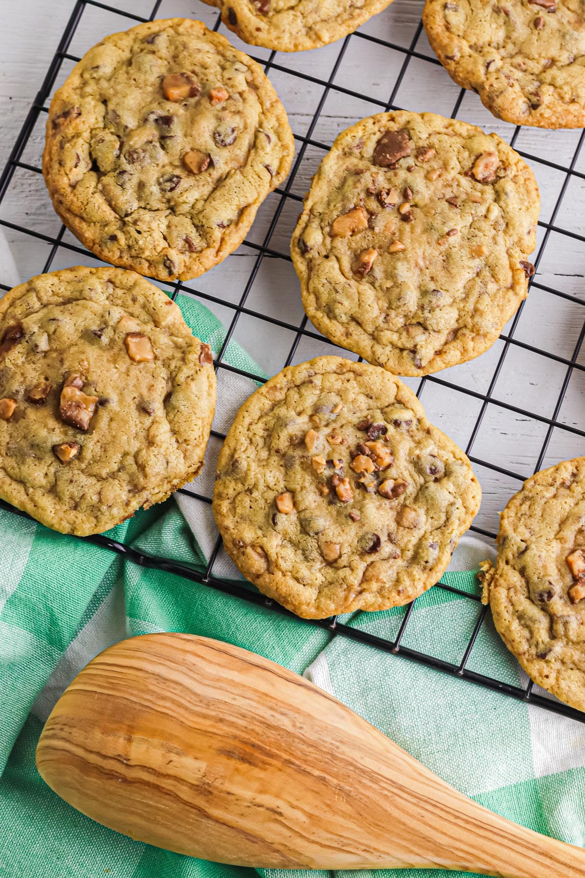 A cooling rack with chocolate chip toffee cookies lined up to cool.