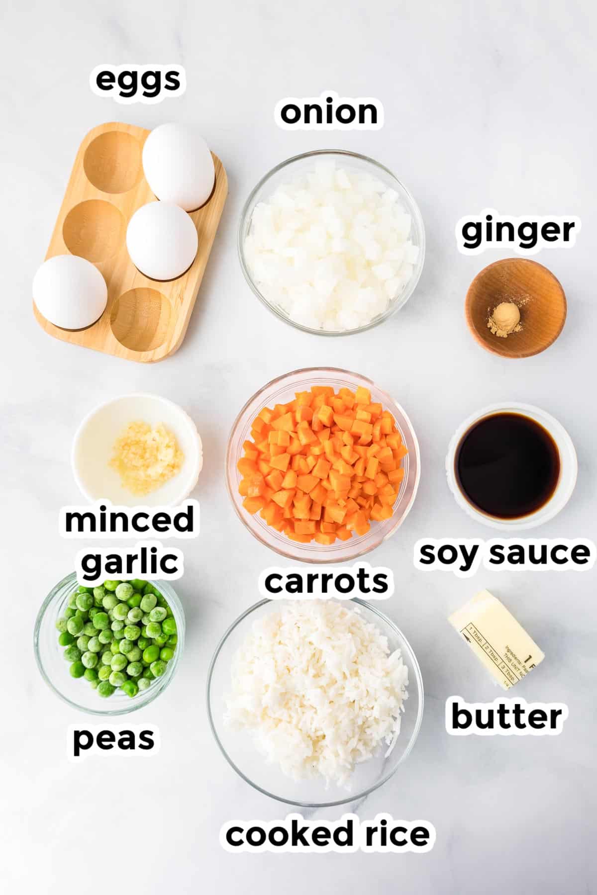 Ingredients for fried rice in bowls on a counter from overhead with text title labels.