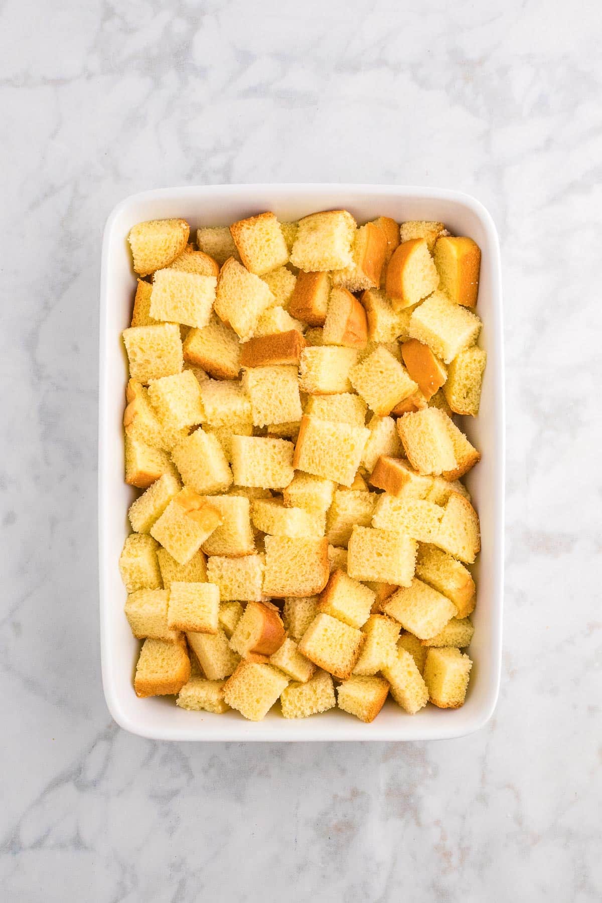 Cubed bread in a casserole dish for apple french toast casserole.