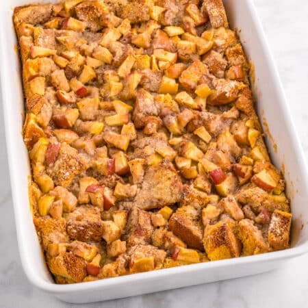 A baking dish filled with apple French toast casserole topped with cinnamon sugar.