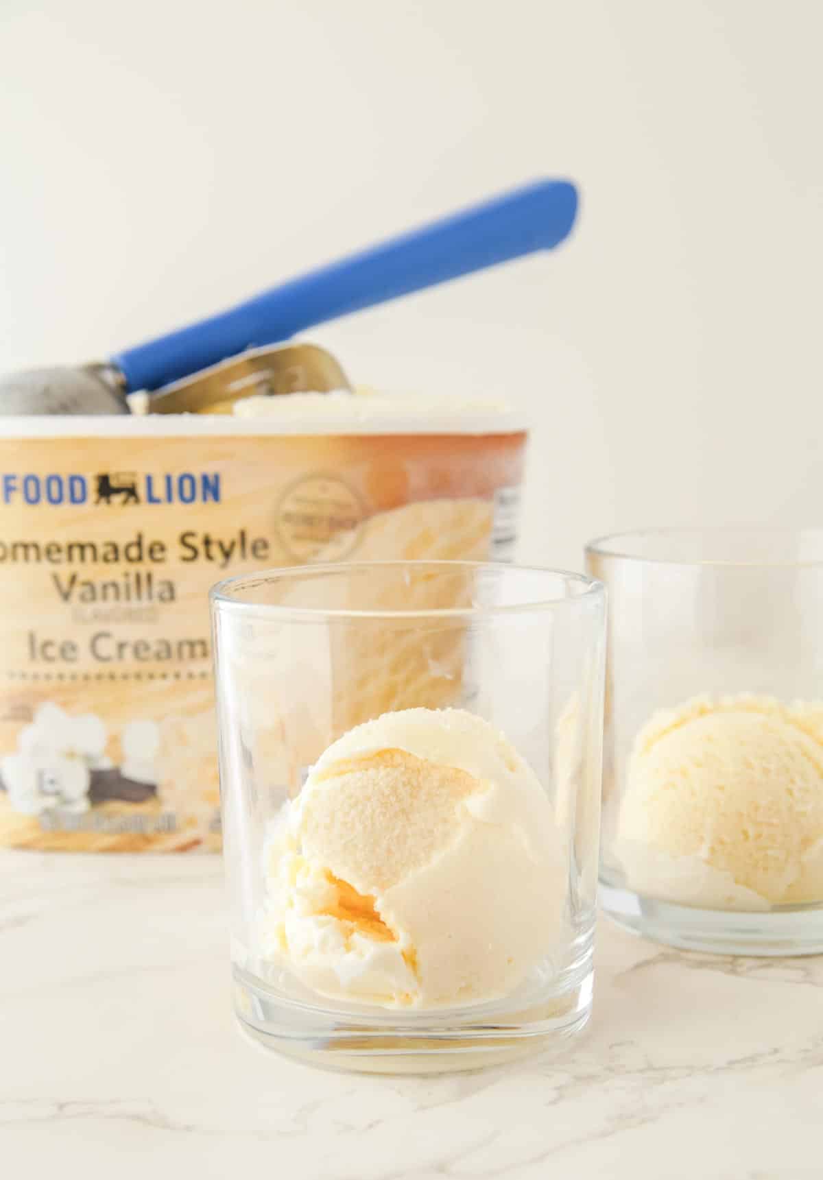 Vanilla ice cream being scooped into glasses for a Halloween punch.