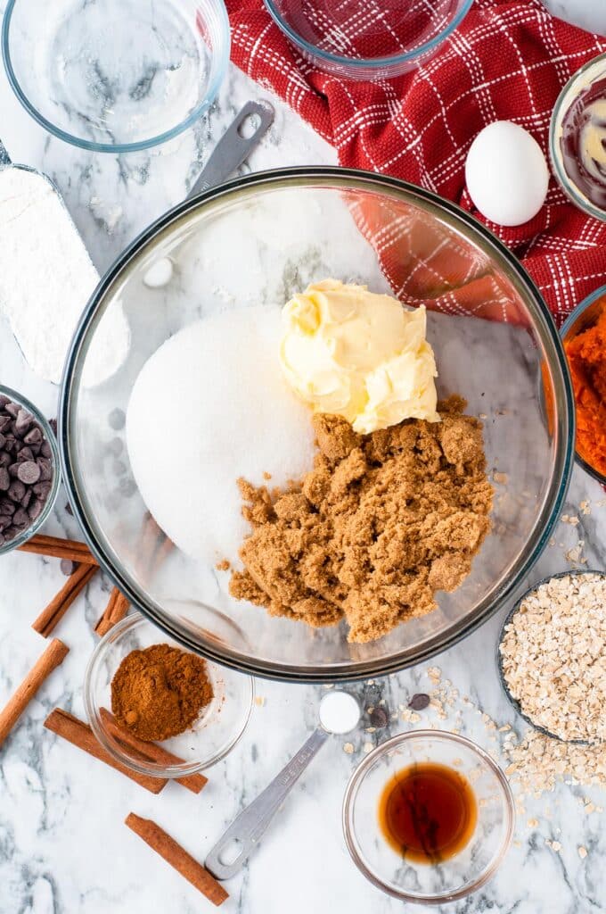 Bowl with sugar, brown sugar, and butter being mixed together.