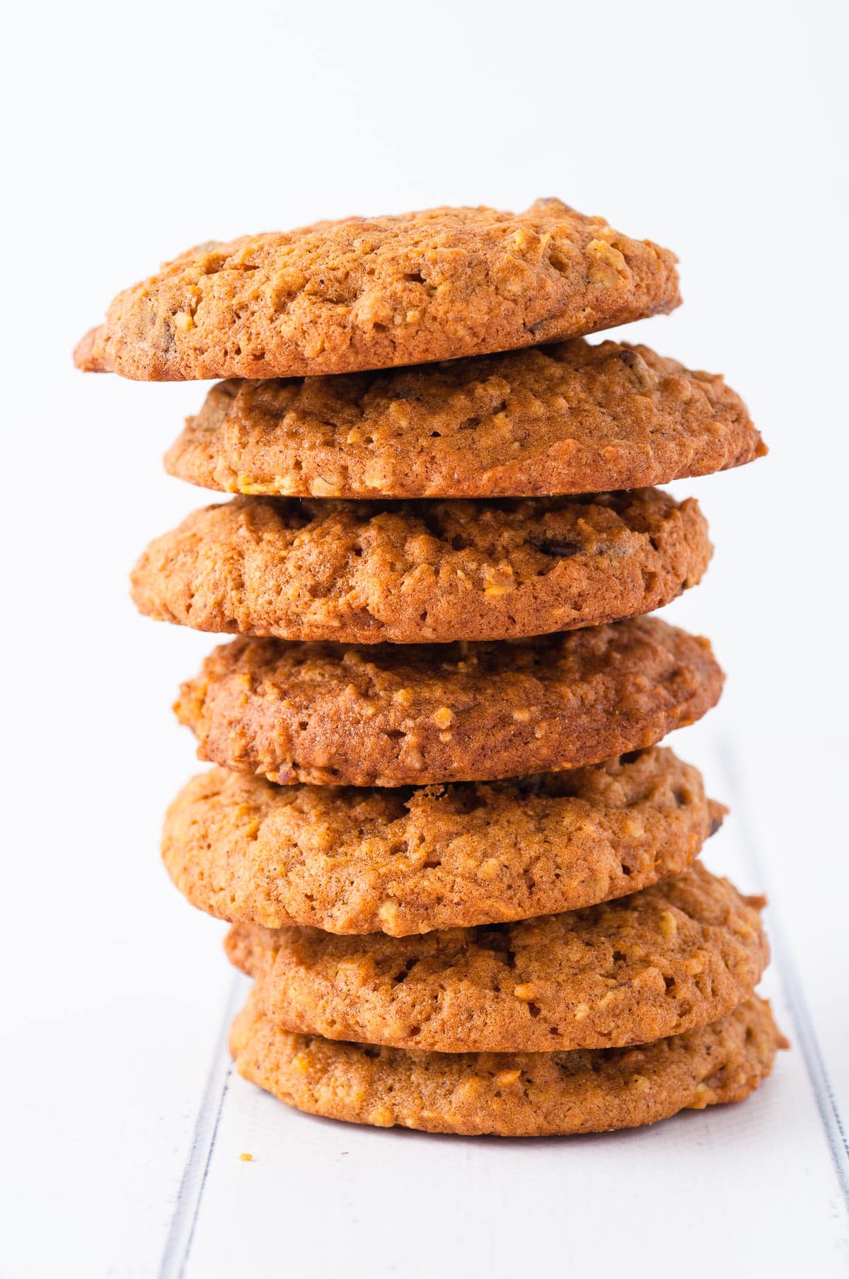 A tall stack of seven homemade oatmeal cookies on a white table.