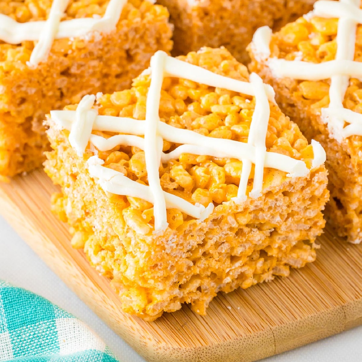 Pumpkin spice rice krispie treat topped with white chocolate sliced on a cutting board.