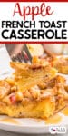 A fork holds a piece of apple French toast casserole above a plate with more casserole and title text across the top of the image.