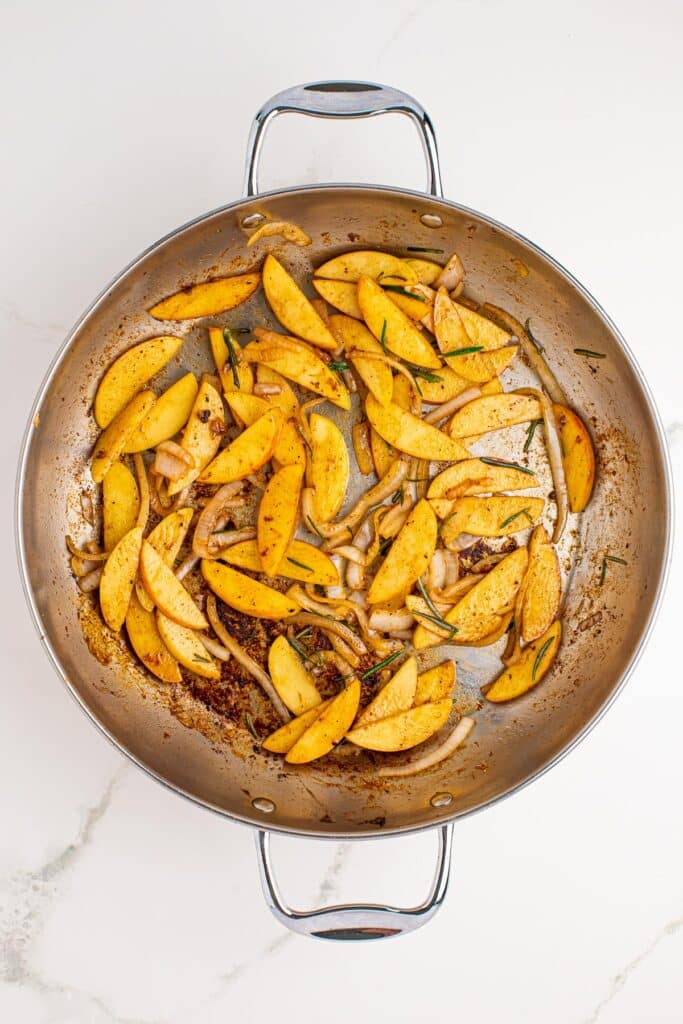 Cooked browned apples and onions in a large skillet.