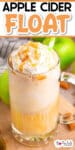 A glass mug filled with an apple cider float topped with whipped cream, caramel drizzle, and a sprinkle of cinnamon. The drink has a straw and is surrounded by green apples. Text at the top reads "Apple Cider Float.