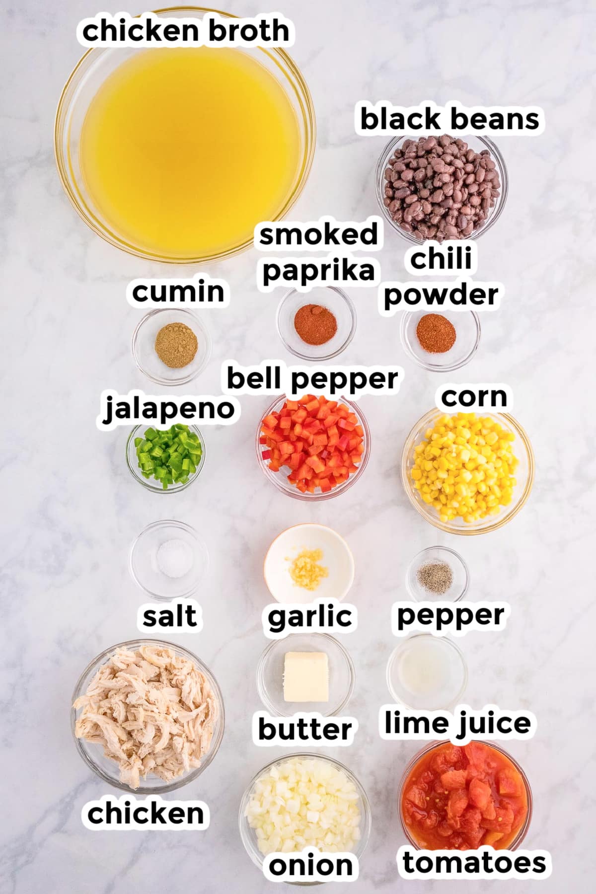 Ingredients for chicken tortilla soup in bowls on a counter with text labels.