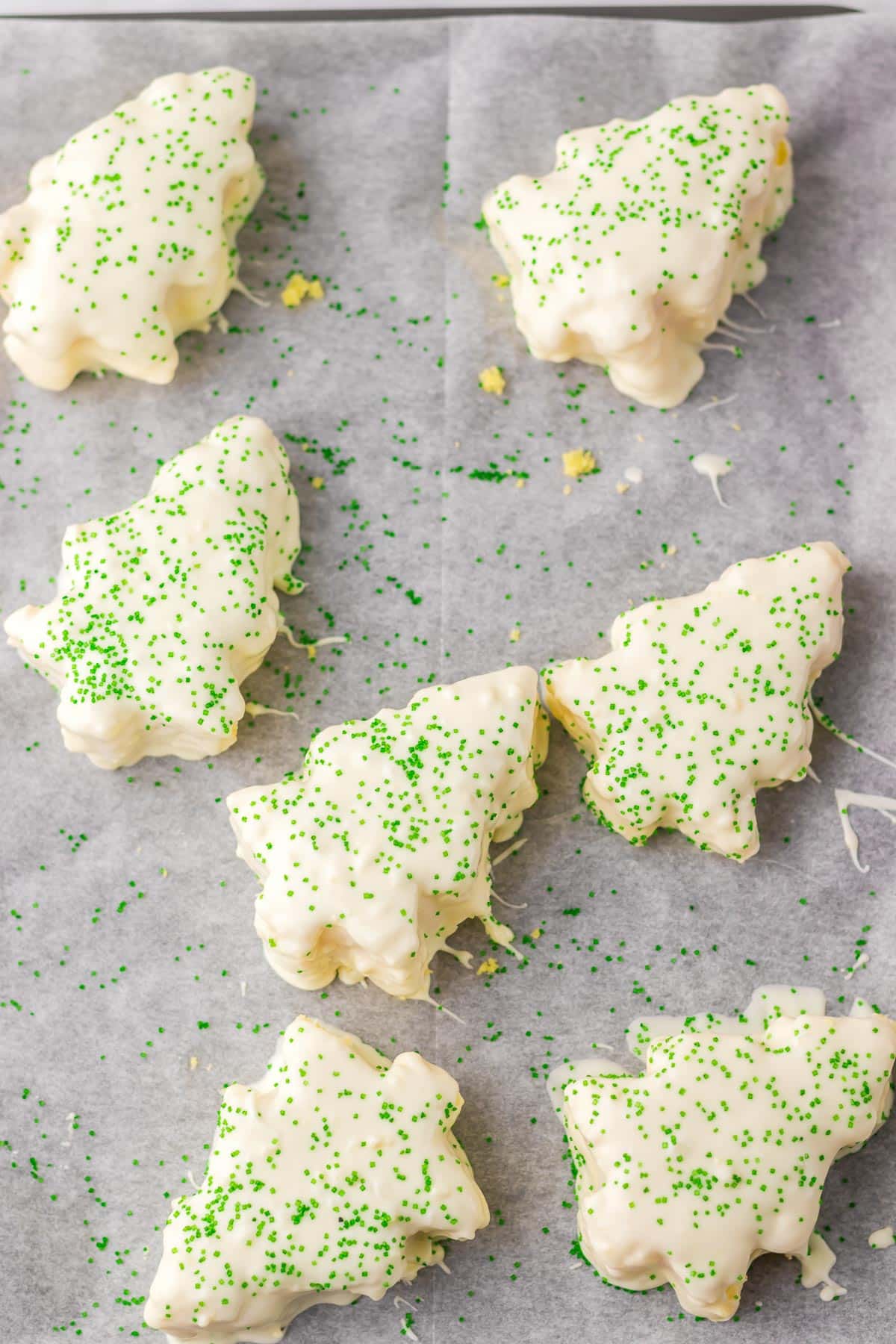 Tree-shaped caked coasted in vanilla almond bard topped with green sprinkles.