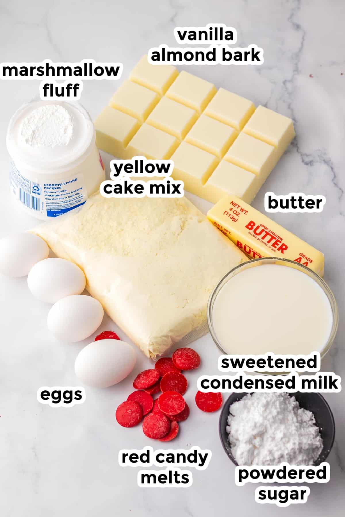 Ingredients for a Christmas tree cakes on a counter in bowls with text labels.